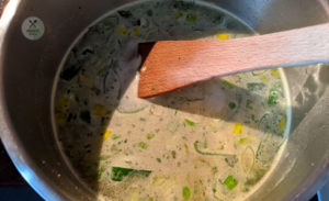 Brühe und Creme Fraiche zur Suppe geben
