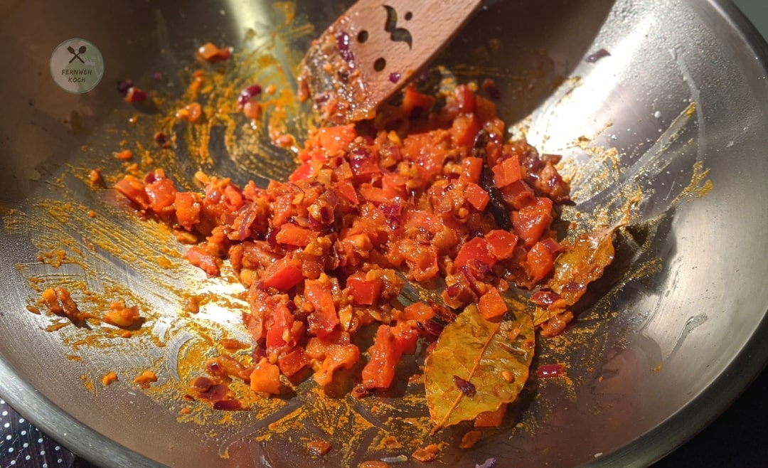Gewürze und Tomaten zum Palak Dal geben Gewürze und Tomaten zum Palak Dal geben