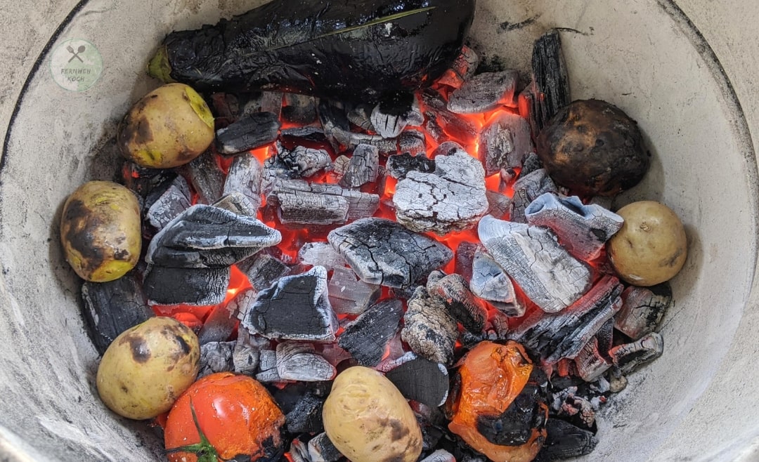 Das Gemüse für indisches Chokha wird direkt im Feuer gegart Das Gemüse für indisches Chokha wird direkt im Feuer gegart